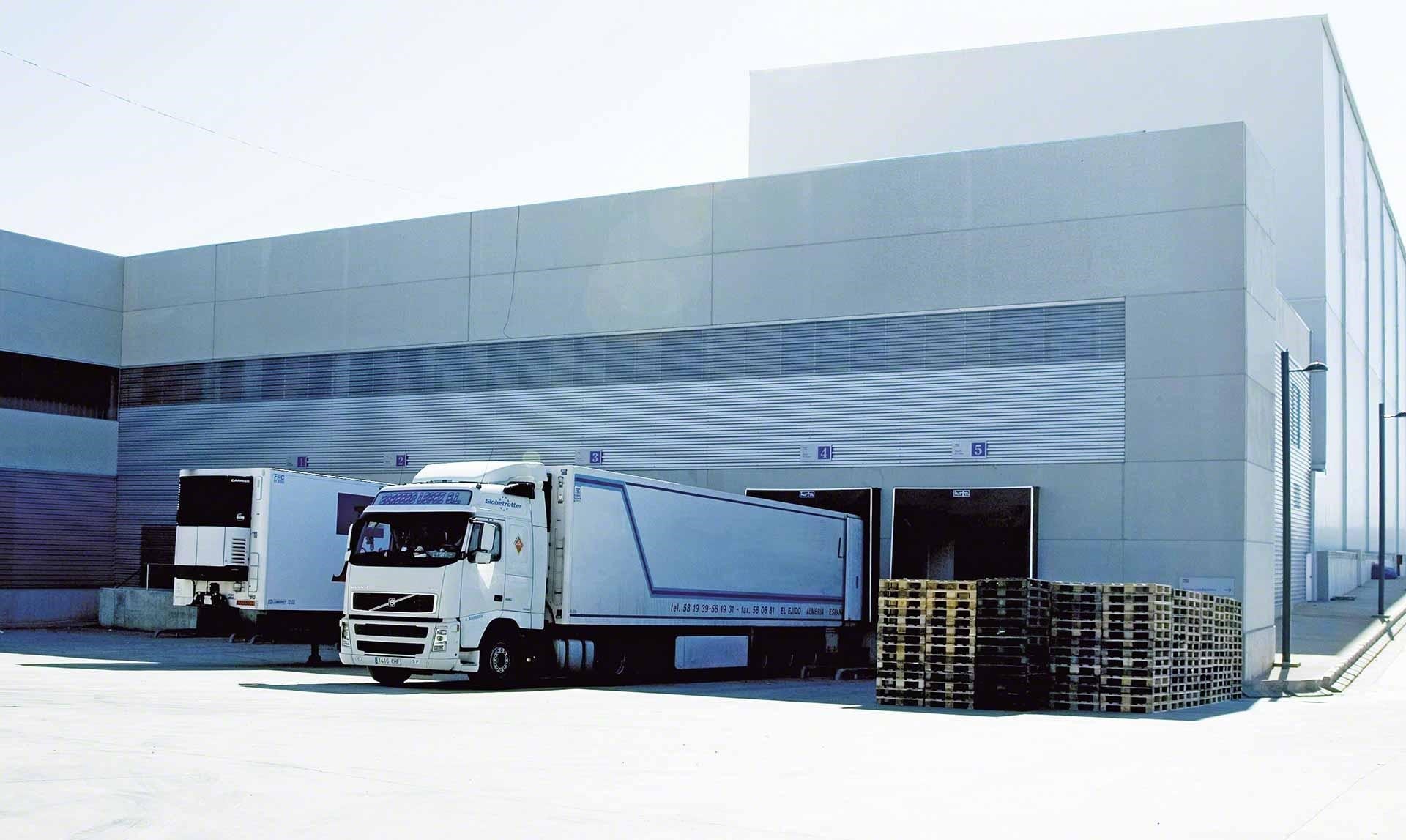 Camiones de mercaderías descargan en el almacén como parte de las operaciones de cross-docking