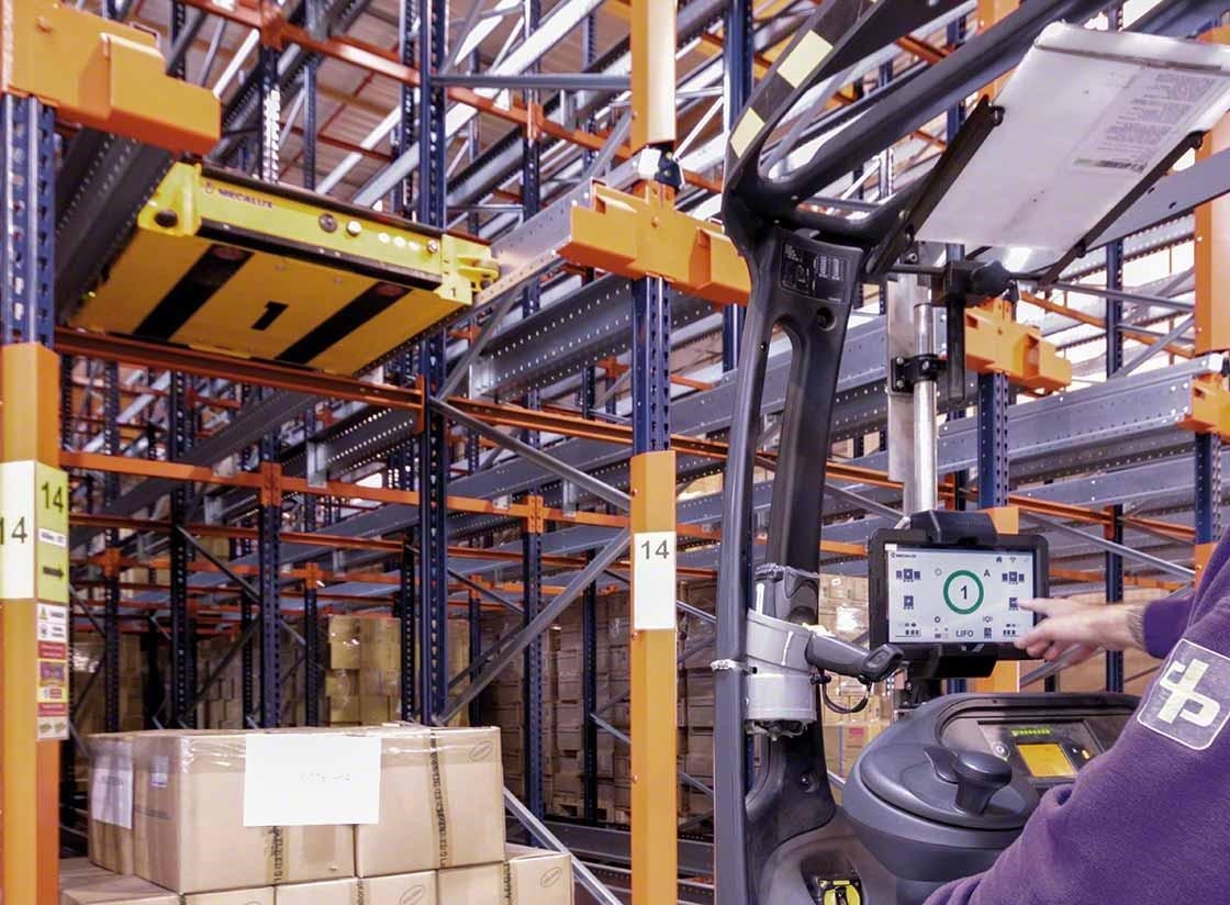 Un operario controla el carro Pallet Shuttle semiautomático desde el montacargas Un operario controla el carro Pallet Shuttle semiautomático desde el montacargas