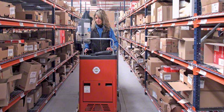 Operaria realizando tareas de picking subida en una máquina preparadora de pedidos