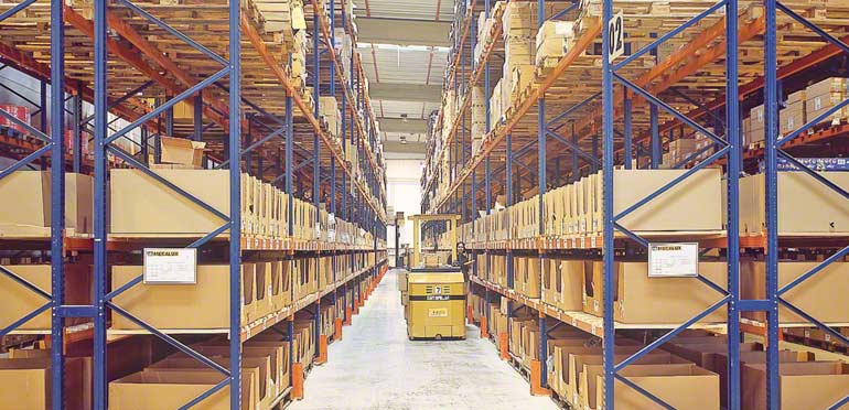 Operario trabajando en un paso inferior en una estantería selectiva